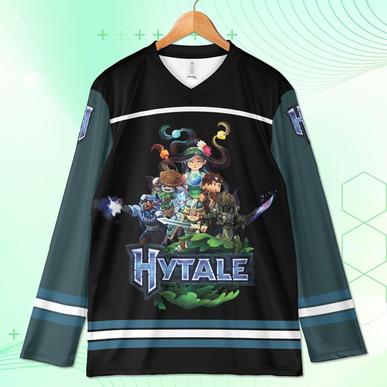 May include: Black and teal hockey jersey with a V-neck and long sleeves. The jersey features a graphic of a group of characters and the word "Hytale" in blue. White stripes accent the sleeves and bottom hem.
