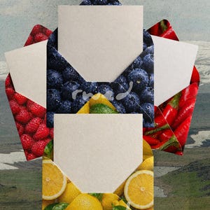 May include: A collection of blank white cards inside decorative envelopes. The envelopes feature vibrant patterns of blueberries, raspberries, lemons, and red chili peppers. The background shows a landscape with mountains and a cloudy sky.