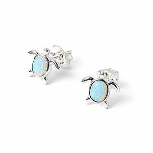 May include: A pair of silver stud earrings shaped like sea turtles. Each earring features a polished silver metal frame with an oval-shaped iridescent opal inlay in the centre of the turtle shell. The earrings include standard silver post backings.