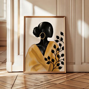May include: Framed art print featuring a stylized portrait of a woman with dark skin, wearing a gold hoop earring and a yellow shawl. A black branch with berries is on the right side. The artwork is in a gold frame.