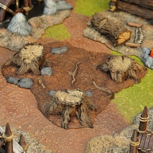 Könnte beinhalten: Eine detaillierte Miniatur-Diorama-Szene mit einem Waldboden mit drei Baumstümpfen, Felsen und grünen Grasflecken. Der Boden ist eine Mischung aus braunen und rotbraunen Tönen, mit einem Baumstamm und einem Holzzaun im Hintergrund. Ideal für Tabletop-Spiele.