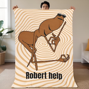 May include: A beige and brown blanket featuring a cartoon character wearing sunglasses and holding a stick. The character is set against a wavy background. The words "Robert help" are printed in black at the bottom.