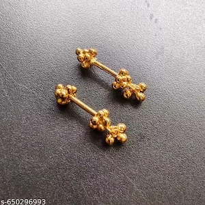 May include: Two gold-colored, barbell-style earrings. Each earring features a central bar with a cluster of small, round beads at each end and a cluster of beads in the middle. The earrings are displayed on a dark gray surface.