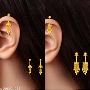 May include: Gold-colored earrings in various styles. One pair features a small stud with a dangling, ornate design. Another pair has a longer, more intricate drop with a floral-like top and dangling elements. The earrings are displayed on a person's ear.