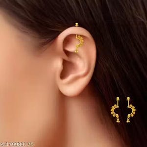May include: A close-up of a person's ear adorned with a gold-colored helix piercing and a matching earring. The helix piercing is a straight bar with a small decorative top. The earring is a crescent shape with dangling accents.