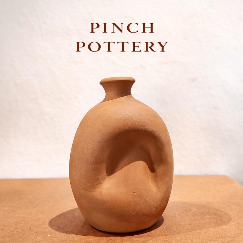 K&ouml;nnte beinhalten: Eine handgefertigte Vase aus Terrakotta mit einer einzigartigen, organischen Form. Die Vase hat einen schmalen Hals und einen abgerundeten K&ouml;rper mit einer eingekniffenen Vertiefung. Der Text "PINCH POTTERY" wird &uuml;ber der Vase angezeigt.