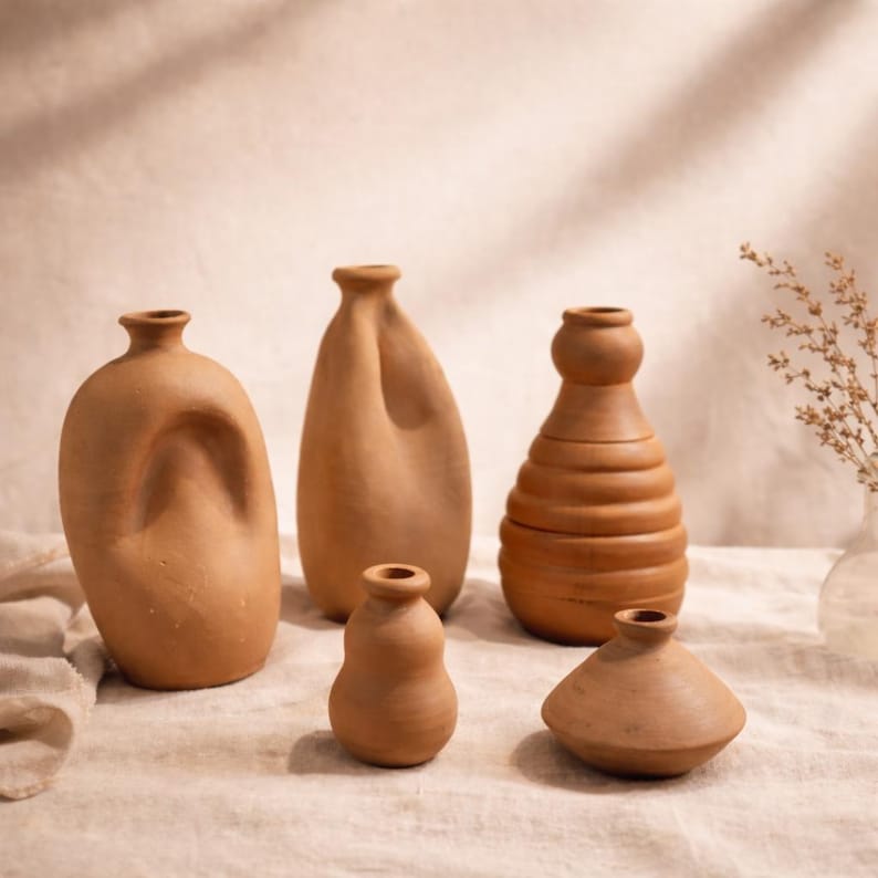 K&ouml;nnte beinhalten: Ein Set aus drei Keramikbechern mit gesprenkelter, cremefarbener Glasur. Jeder Becher zeigt ein handgemaltes Blumendesign in Blau-, Gr&uuml;n- und Gelbt&ouml;nen. Die Becher haben eine einfache, abgerundete Form und einen bequemen Griff.