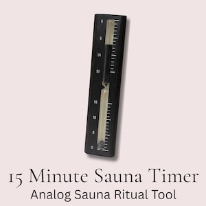 Op de afbeelding: Een zwarte 15-minuten saunatijdmeter met witte markeringen en een doorzichtige, met vloeistof gevulde buis. De timer heeft een rechthoekige vorm en is ontworpen voor analoge saunarituelen. De tekst "15 Minute Sauna Timer" en "Analog Sauna Ritual Tool" wordt onderaan weergegeven.