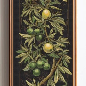 May include: A framed cross-stitch of an olive tree branch with green and yellow olives. The leaves are various shades of green. The background is dark with a decorative border. The frame is a light brown color.
