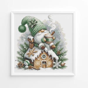 May include: A framed watercolor print of a gnome wearing a green hat and scarf, sitting on a gingerbread house covered in snow. The gnome is holding a mug and smoking a pipe, with pine needles and snowflakes surrounding the house.