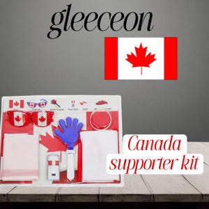 Op de afbeelding: Een Canada supporter kit met een bril, een cheer clapper, schmink, een sjaal en een armband. De kit bevat de Canadese vlag en esdoornbladmotieven. De tekst "Canada supporter kit" is zichtbaar.