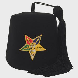 May include: Black fez hat with a star emblem in yellow, red, blue, and green. The hat has a black tassel and a small black cord at the top. The star emblem features various symbols.