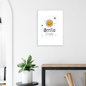 Könnte beinhalten: Ein gerahmter Kunstdruck mit weißem Rand. Das Kunstwerk zeigt ein gelbes Smiley-Gesicht, die Worte "Smile Everyday" in Schwarz und teal Diamanten auf weißem Hintergrund mit einem Rastermuster. Der Druck wird an einer weißen Wand angezeigt.