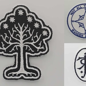 May include: Embroidered patches featuring designs from a fantasy novel. One patch is a black and white tree, another is a compass with the text "NOT ALL THOSE WHO WANDER ARE LOST", and the third is an oval with a symbol.