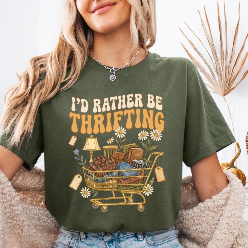 A shopping cart illustration filled with vintage items like a lamp and plates, with the text I'd Rather Be Thrifting above it.