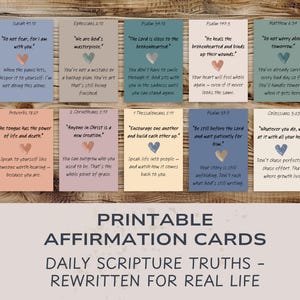 Può includere: Una collezione di biglietti di affermazione stampabili con verità delle Scritture quotidiane riscritte per la vita reale. Ogni biglietto presenta una citazione e un cuore. I biglietti sono disposti su una superficie di legno.