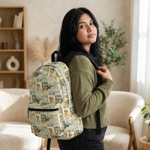 Könnte beinhalten: Ein Rucksack mit einem sich wiederholenden Muster aus Illustrationen in Beige-, Grün- und Brauntönen. Er hat eine schwarze Reißverschlusstasche und schwarze Schultergurte. Der Hintergrund ist ein hellgrünes Karomuster.