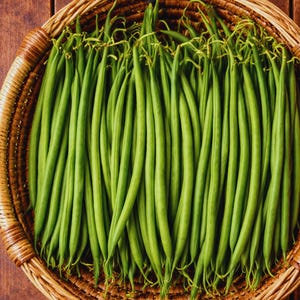 May include: A woven basket filled with fresh, vibrant green string beans. The beans are long and slender, with a bright green color. The basket is made of light brown wicker and sits on a dark wooden surface.