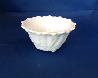 May include: White ceramic bowl with a textured, ruffled design. The bowl is empty and has a smooth, glossy finish.