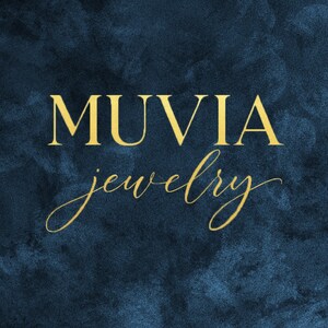 the word "MUVIA" in a stylized font, with the word "jewelry" below it, against a dark blue background.