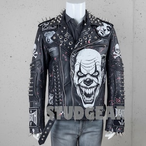 Może przedstawiać: Czarna skórzana kurtka ze srebrnymi kolcami, naszywkami i dużą białą grafiką twarzy klauna. Kurtka posiada naszywkę Route 66, czaszki i napis "DEATH".
