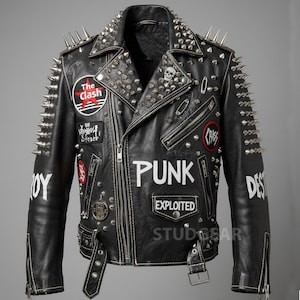 Può includere: Giacca in pelle nera con borchie argentate sulle spalle e sul colletto. La giacca presenta diverse toppe e la scritta "PUNK" in lettere bianche. Cerniere e fibbie completano il design.