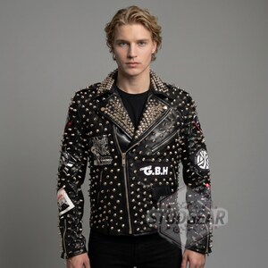 May include: Black leather jacket with silver studs and spikes. The jacket has a zipper closure, multiple patches, and the letters "G.B.H." on the front. The collar and shoulders are heavily studded.
