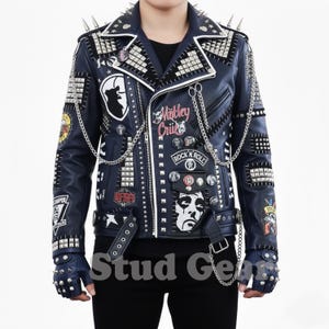 May include: A navy blue leather jacket with silver studs, spikes, and patches. The jacket features the text "Motley Crue" and "Rock N Roll". Includes matching studded fingerless gloves.