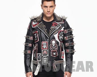 Puede incluir: Chaqueta de cuero negra con púas plateadas en los hombros y las mangas. La chaqueta presenta múltiples parches con calaveras y otros gráficos. Un cinturón blanco con tachuelas plateadas completa el look.