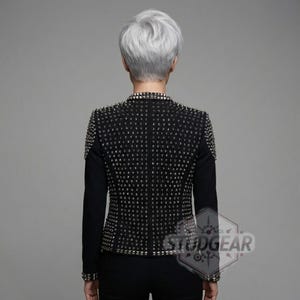 Rear view of silver studded black leather blazer showing dense spike pattern on shoulders