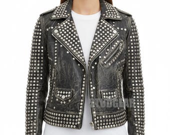 May include: A distressed black leather jacket with silver stud embellishments. The jacket features a classic asymmetrical zip closure, multiple pockets, and studded detailing on the collar, shoulders, and sleeves. The jacket is worn over a white t-shirt.