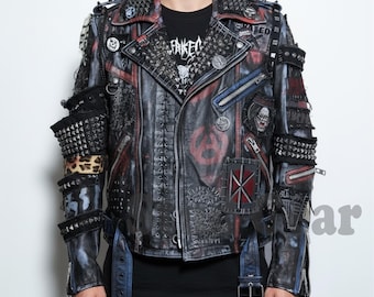 May include: A black leather jacket with red and blue accents, adorned with metal studs, patches, and zippers. The jacket features a studded collar and cuffs, and the text "FAKED" is visible on a black t-shirt underneath.