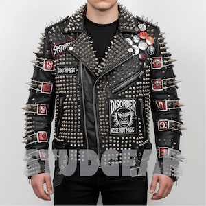 Puede incluir: Chaqueta de cuero negro muy adornada con tachuelas y púas plateadas. Los parches incluyen "Discharge" y "Disorder Noise Not Music". La chaqueta tiene múltiples botones y cremalleras. Un estilo punk rock.