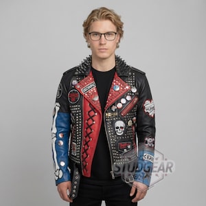 May include: Black leather jacket with red and blue accents, adorned with metal studs, patches, and the word "DISCHARGE". The jacket features a skull graphic and a studded collar, showcasing a punk rock aesthetic.