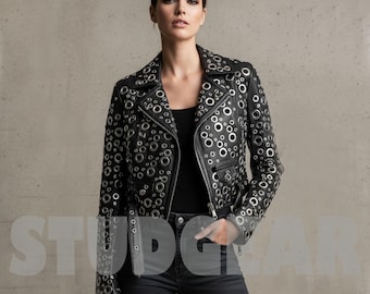 May include: Black leather jacket with silver grommets. The jacket has a classic biker style with a notched collar, asymmetrical zipper, and multiple pockets. The grommets are evenly spaced across the jacket, creating a unique and edgy look. The model is wearing black jeans and a black top.