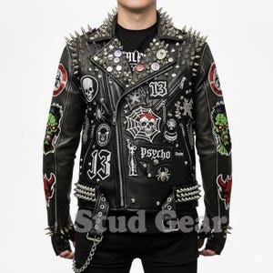 May include: Black leather jacket with silver spikes on the shoulders, collar, and cuffs. The jacket is adorned with patches featuring skulls, spiders, and the number 13. Additional metal studs and pins decorate the front.