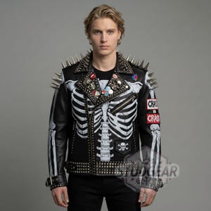 May include: Black leather jacket with a white skeleton design, silver studs, and spikes. The jacket features a skull and crossbones emblem and patches that read "CRAS".