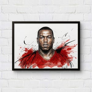 May include: A framed art print featuring a portrait of a person in a red shirt. The artwork uses a watercolor style with red and black brushstrokes. The portrait is set against a white background.