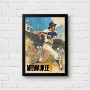 Könnte beinhalten: Gerahmter Druck mit einem Baseballspieler in einem Brewers-Trikot beim Schwingen. Das Kunstwerk hat einen Vintage-Stil mit einem schwarzen Rahmen und dem Wort "MILWAUKEE" in fetten Buchstaben unten. Der Hintergrund zeigt andere Spieler und ein Stadion.