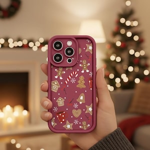Peut inclure: Coque de téléphone bordeaux avec un thème de pain d'épices festif. Le motif répété comprend des bonhommes en pain d'épices, des maisons, des étoiles et des cannes en sucre. Le boîtier a un bord surélevé autour des objectifs de l'appareil photo.