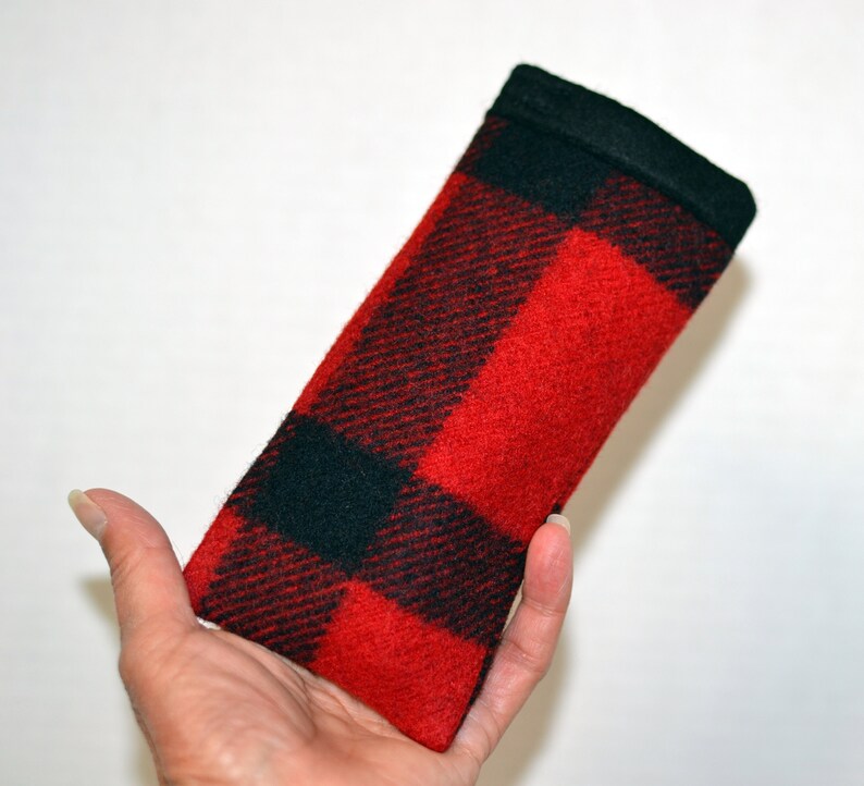 K&ouml;nnte beinhalten: Ein rechteckiges Brillenetui mit einem rot-schwarzen Karomuster. Das Etui hat eine schwarze Oberseite und besteht aus einem strukturierten Stoff. Das Etui dient zum Schutz von Brillen.