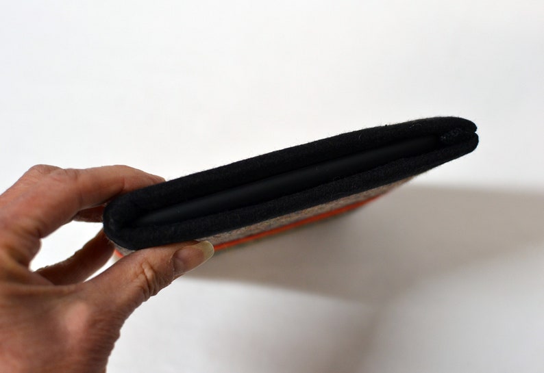 May include: A black and brown fabric case with a zipper closure. The case is folded in half and has a textured fabric exterior.