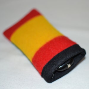 May include: A red, yellow, and black striped glasses case made of soft fabric.