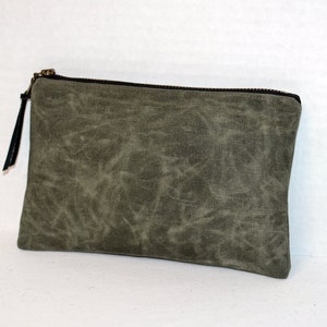 May include: A green canvas zippered pouch with a black zipper pull.