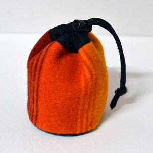 May include: A small orange, red, and black drawstring bag with a black cord.