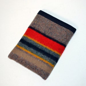 May include: A brown, black, red, yellow, and green striped wool pouch with a black fabric border.