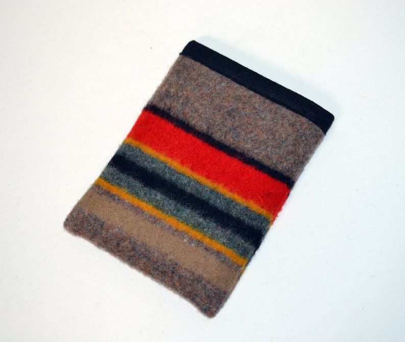 May include: A brown, black, red, yellow, and green striped wool pouch with a black fabric border.