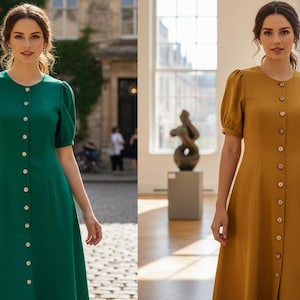 May include: Two dresses, one emerald green and one mustard yellow, are featured. Both dresses have a button-down front, short sleeves, and a midi length. The dresses are worn in different settings, one outdoors and one indoors.