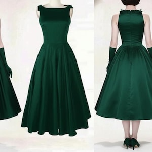 Peut inclure: Robe en satin vert fonc&eacute; avec une jupe &eacute;vas&eacute;e et un corsage ajust&eacute;. La robe pr&eacute;sente un col montant et est pr&eacute;sent&eacute;e avec des gants et des talons assortis. La robe arrive au genou et a un style vintage.