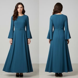 Pode incluir: Vestido longo azul-petr&oacute;leo com mangas compridas e largas e cinto a condizer. O vestido tem decote redondo e saia fluida. A imagem mostra o vestido pela frente e por tr&aacute;s, destacando o seu design e caimento. Adequado para ocasi&otilde;es formais.